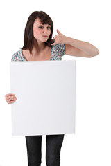 Brown-haired girl holding white panel for message