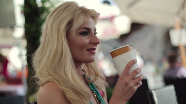 Young attractive woman drinking coffee in cafe, steadicam shot
