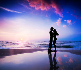 Romantic couple in love on beach at sunset