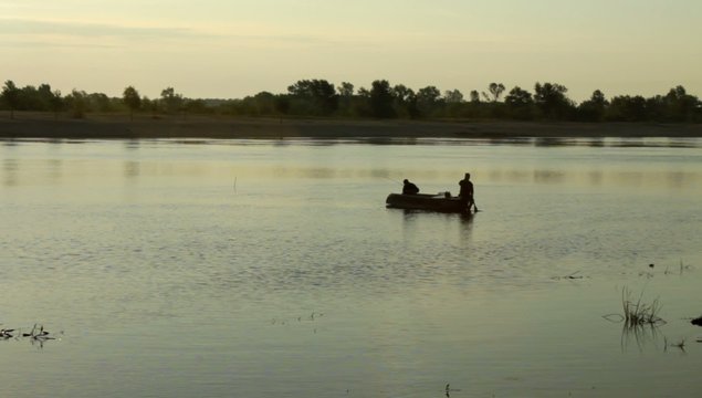 river fishermen in the boat at dawn