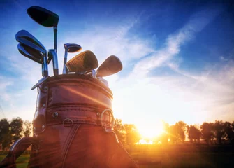 Papier Peint photo Lavable Golf Équipement de golf, clubs au coucher du soleil sur le terrain de golf