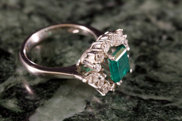 Ring with emerald and diamonds on Carrara marble