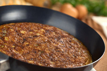 Preparing Spanish tortilla (omelette with potatoes) in pan