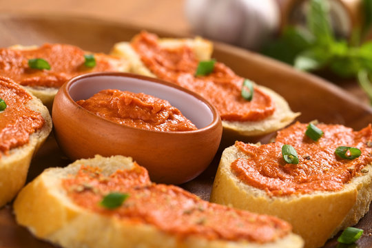 Tomato-butter spread in bowl with sandwiches around