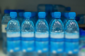 Bottles with fresh water on shelves insupermarket