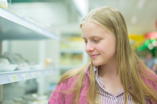 Young woman near shelves in supermarket