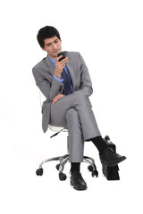 Young man in suit sending text message