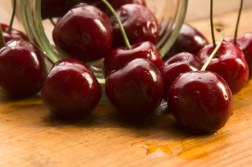 Cherry in glass jar isolated on the wooden background
