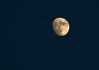 Fototapeta premium Airliner flying along the moon in dusk
