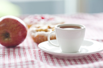 beautiful cake with berries,apple and tea on plaid fabric