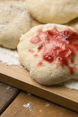 Dough with marmelade on wooden board