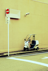 Motor scooters parked beside the wall with no entry sign