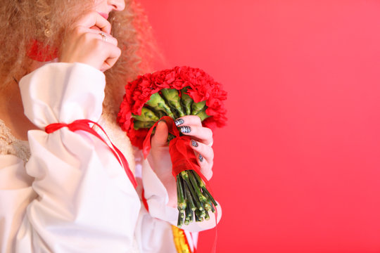 hands of bride wearing white dress hold bouquet
