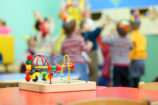 Colorful wooden toy stand at red table in kindergarten;