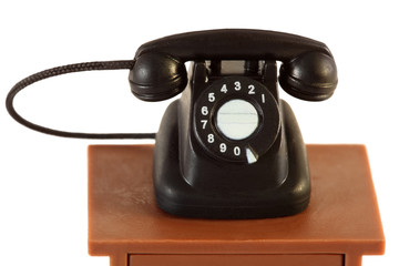 little retro black telephone on brown table isolated