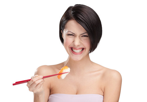 Smiling young female holding sushi with a chopsticks