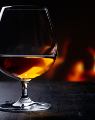 Brandy snifter warming before a glowing fire