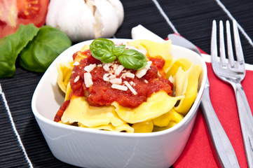 Tortellini with blurred ingredients in the background