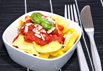Tortellini in a bowl on black background