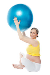 Smiling pregnant woman with a ball