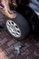 Car mechanic changing wheel