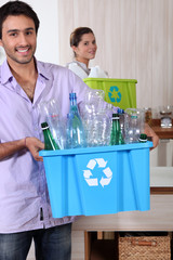 Couple recycling plastic bottles