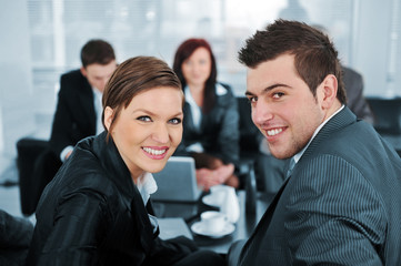 Businessman and businesswoman looking at camera