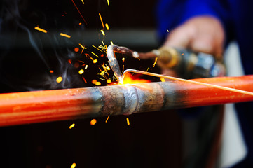 welder using torch on metal object