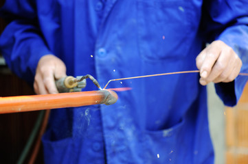 Worker in blue suit welding metal