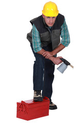 plumber with leg resting on toolbox