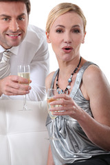 Blond woman holding champagne glass surprised expression