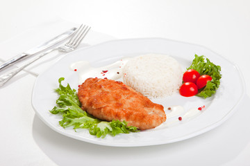 meat with mixed leaf salad an rice on white