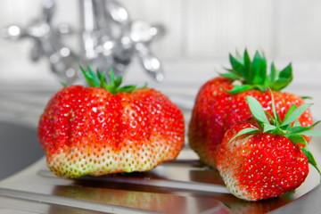 Washed fresh strawberries at the kitchen tap