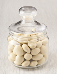 Fototapeta na wymiar white chocolate balls with almond heart. in a glass jar
