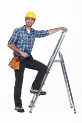 Man with drill climbing ladder