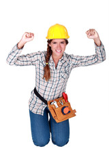 happy craftswoman kneeling and raising her hands