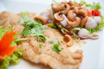 Deep fried fish serve with spicy salad and vegetables
