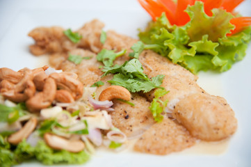 Deep fried fish serve with spicy salad and vegetables