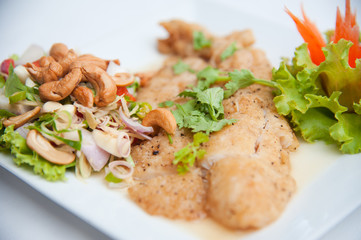 Deep fried fish serve with spicy salad and vegetables