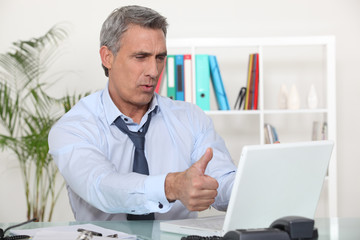 Obraz premium Middle-aged office worker giving thumbs-up
