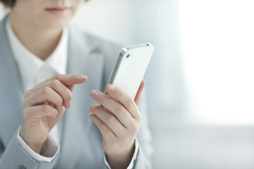 スマートフォンを操作する女ビジネスウーマン