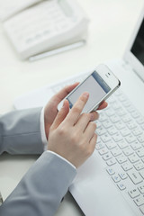 スマートフォンを操作するビジネスウーマン