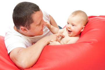 father with baby on red sofa