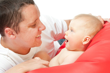 father with baby on red sofa