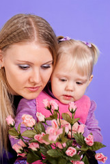 Pretty Caucasian mama and daughter with flowers