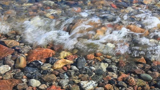 Wellen brechen sich am steinigen Ostseestrand
