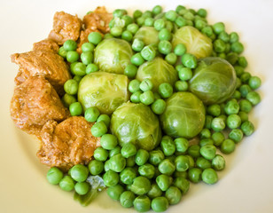 Fresh stew of beef and pork with green peas and Brussels sprout
