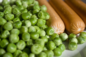 Boiled sausages with boiled green peas as a side dish