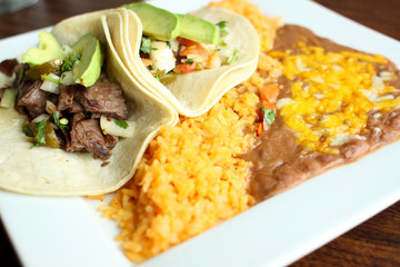Steak soft tacos with beans and rice at a Mexican restaurant.
