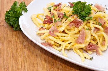 Spaetzle with parsley on wooden background